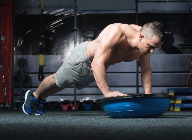 fitness man demonstrating Bosu ball pushups