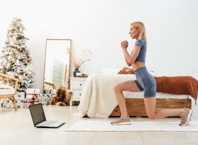 woman doing Christmas countdown workout in festive bedroom