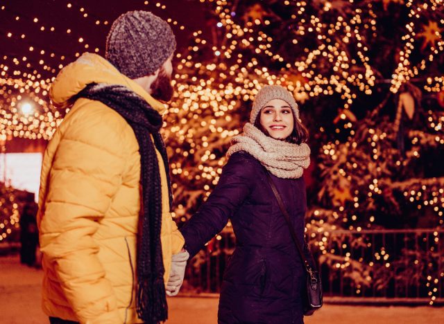 happy couple walking and looking at christmas lights display