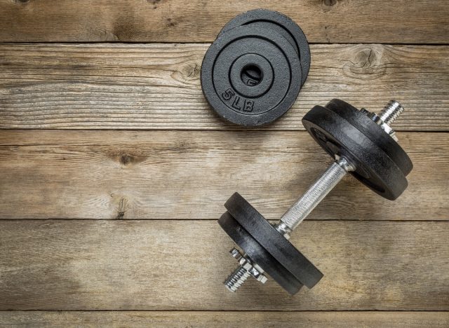 one dumbbell on wooden floor