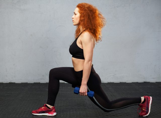 woman doing dumbbell walking lunges to lose the extra five pounds