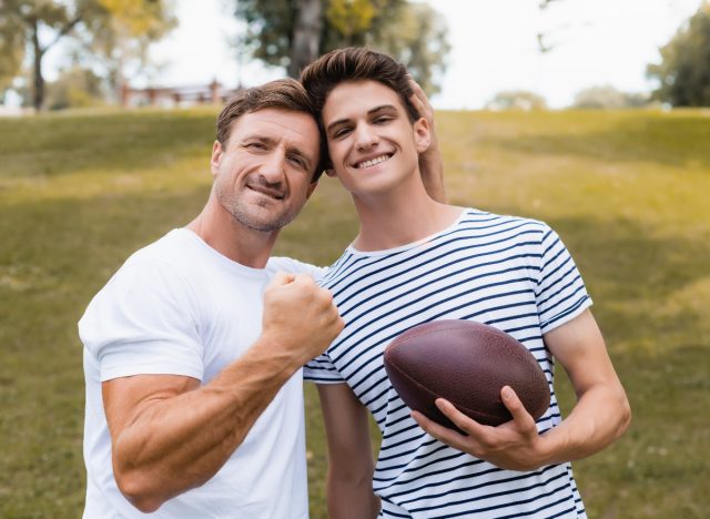 father and son playing football