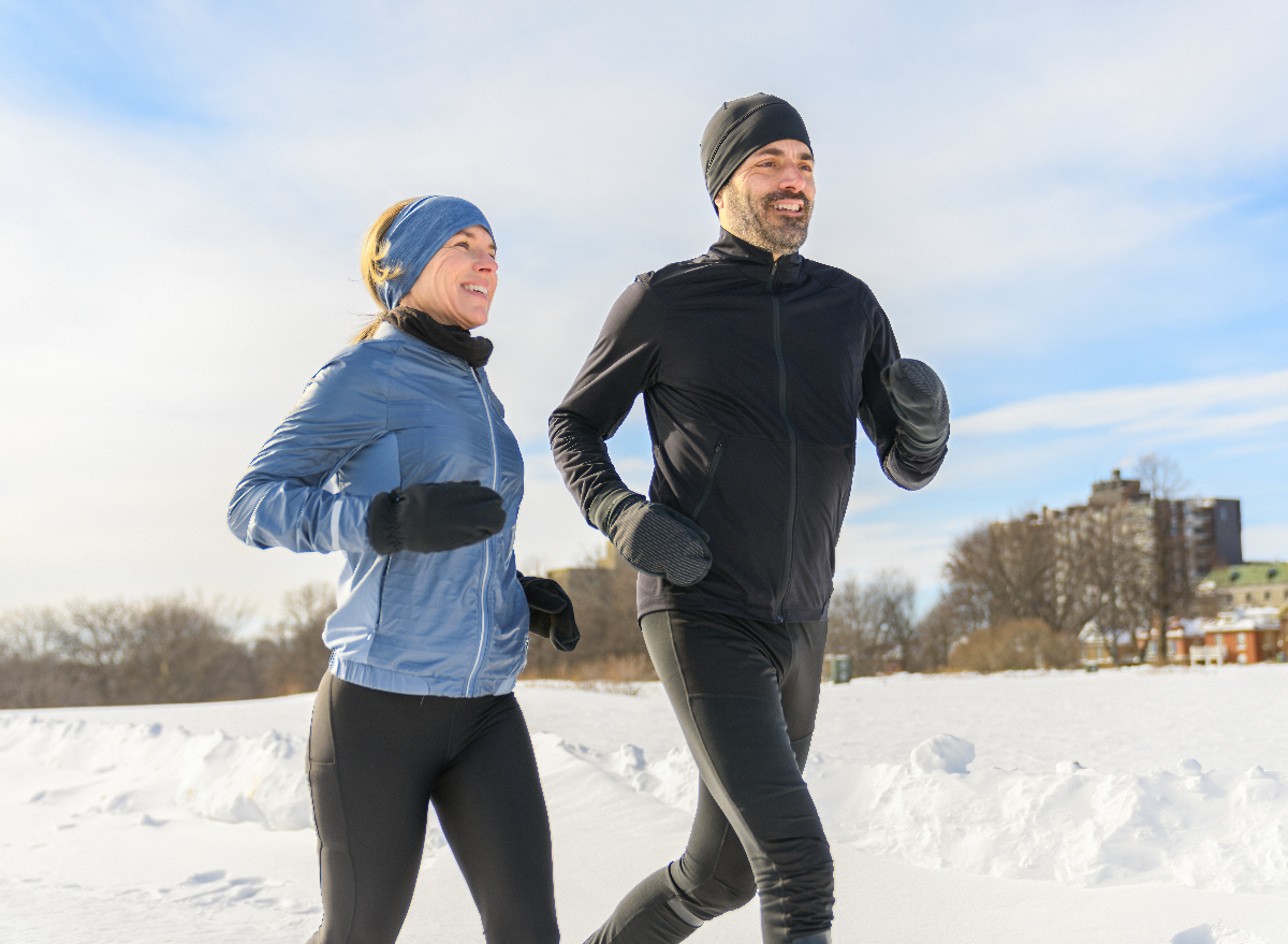 fit couple demonstrating how to get out of winter workout rut with snowy outdoor run