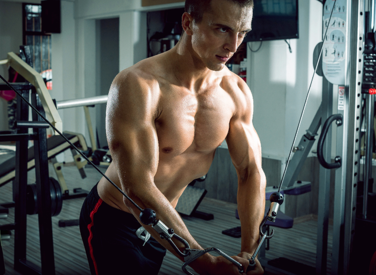 fitness man at gym doing inner chest workout, cable chest fly