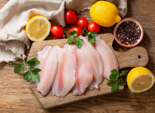 fresh tilapia, lemons, pepper, and tomatoes