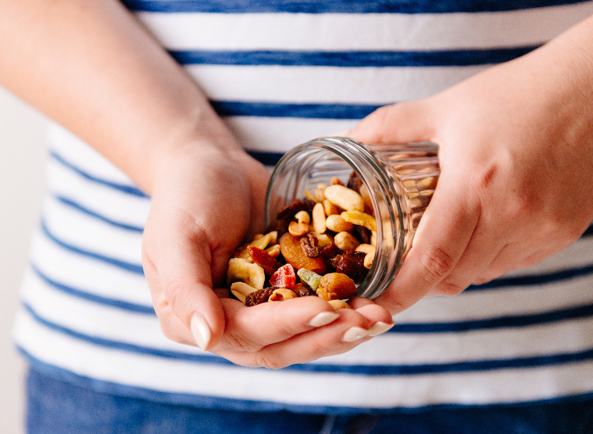 hands pouring jar of nuts and dried fruit