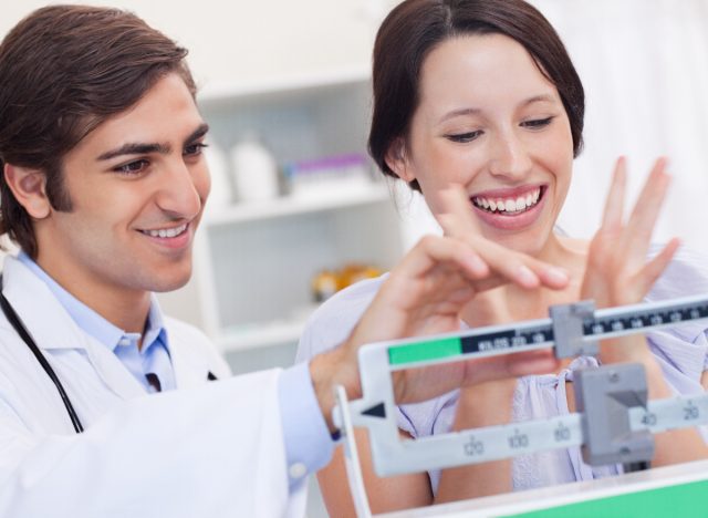 happy woman celebrating her weight loss during check-up