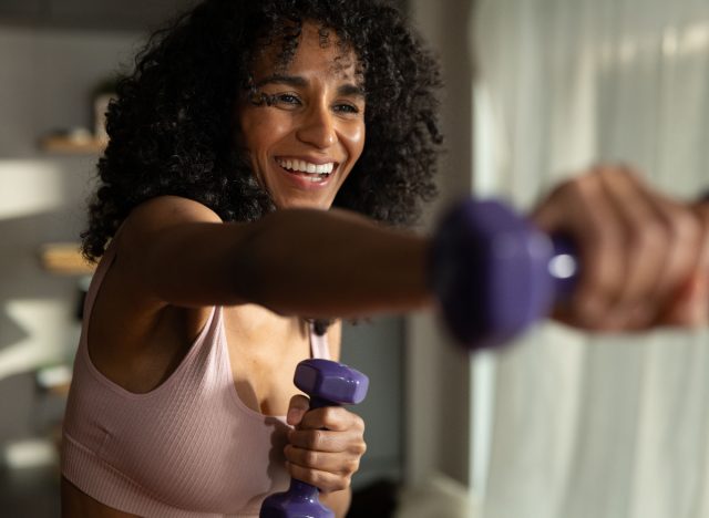 woman doing a high-intensity cardio workout with dumbbells