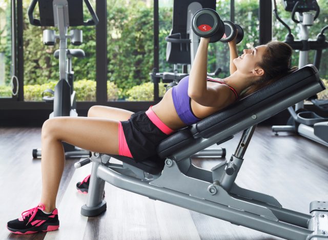 woman doing incline dumbbell bench press to get in shape in 30 days
