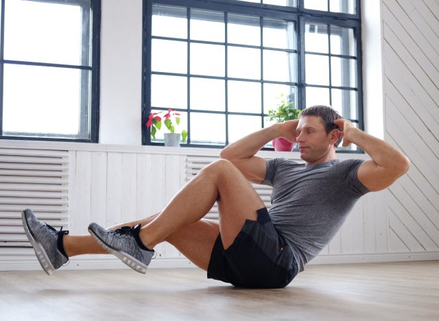 mature man doing floor bodyweight exercises to melt lower belly fat
