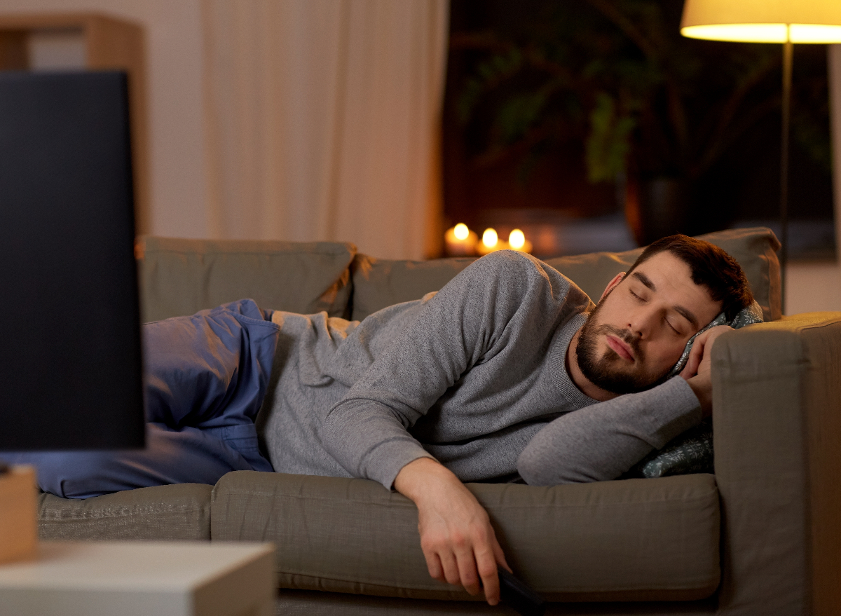 man napping getting junk sleep on couch in front of TV