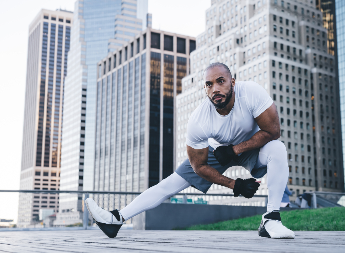 man doing simple-at-home exercises to lose belly fat on rooftop cityscape