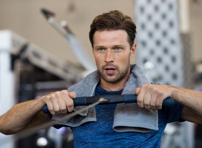 fit man on rowing machine demonstrating exercise habits for strong forearms