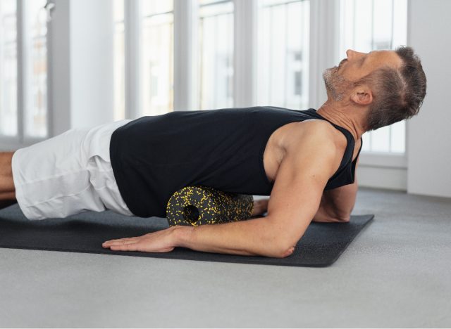 mature man foam rolling his back