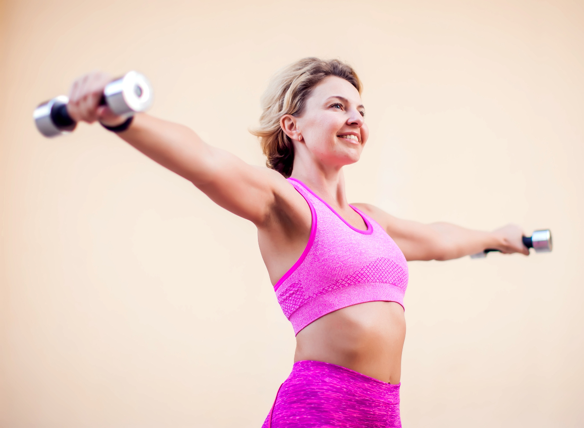 mature woman doing dumbbell arm raise exercise for wrinkly elbows