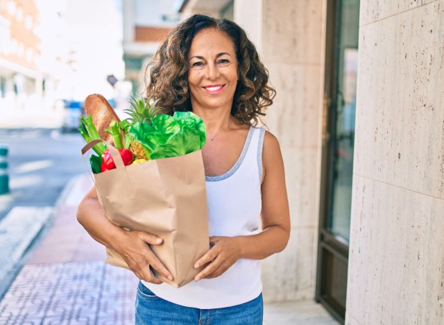 mature woman holding groceries demonstrating habits to maintain muscle mass after 50