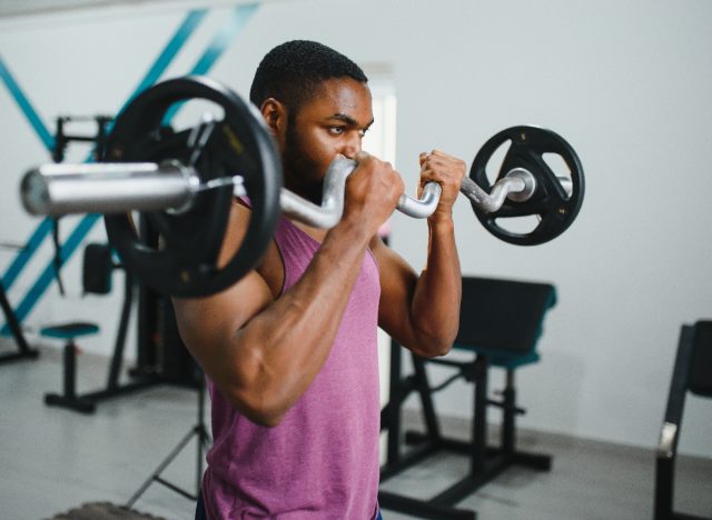 muscular man at gym lifting barbell