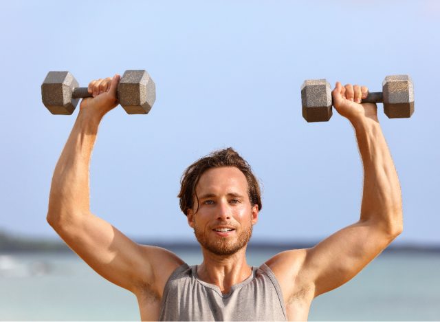 man on beach demonstrating overhead press exercise workout for rapid weight loss
