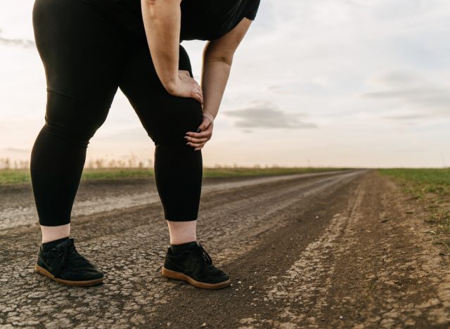 overweight woman experiencing knee pain while walking, concept of the signs you need to lose weight