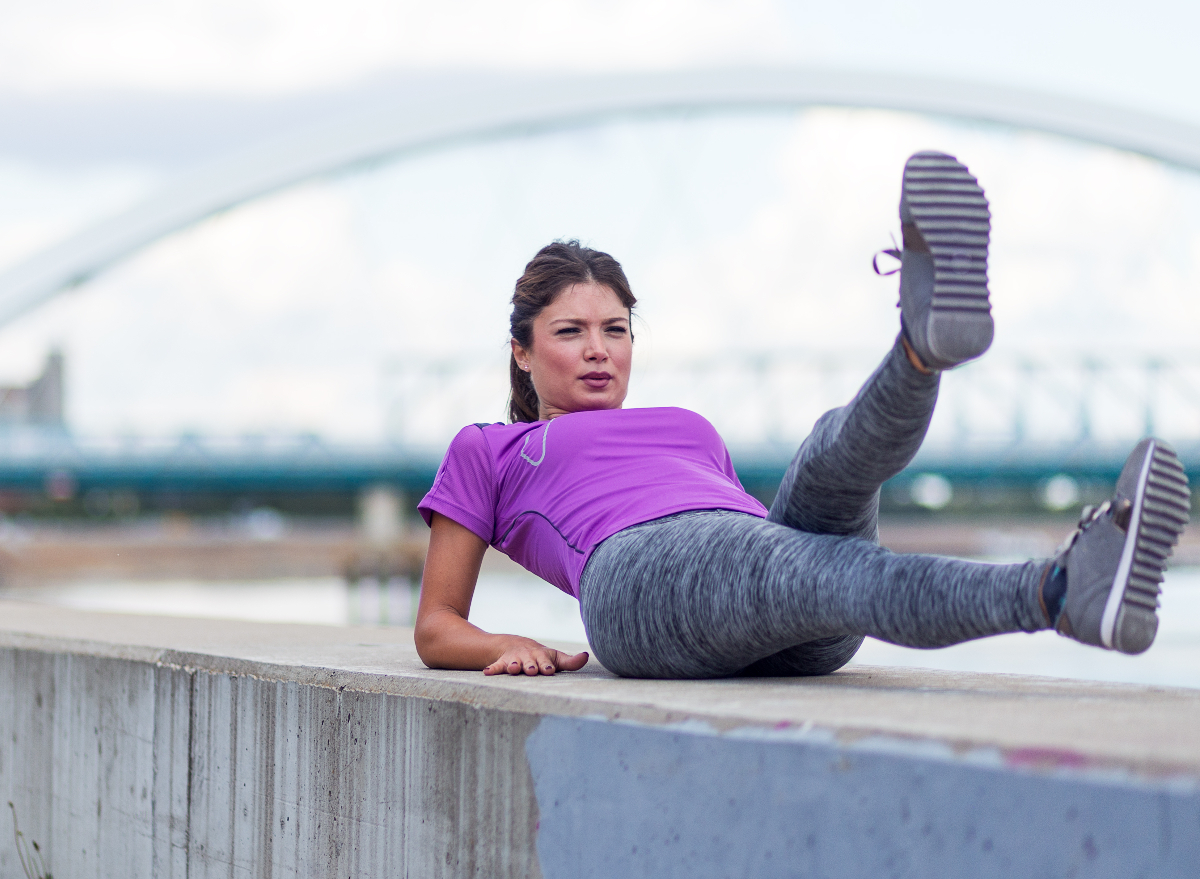 fit woman demonstrating scissors exercise to lose inches off your waist