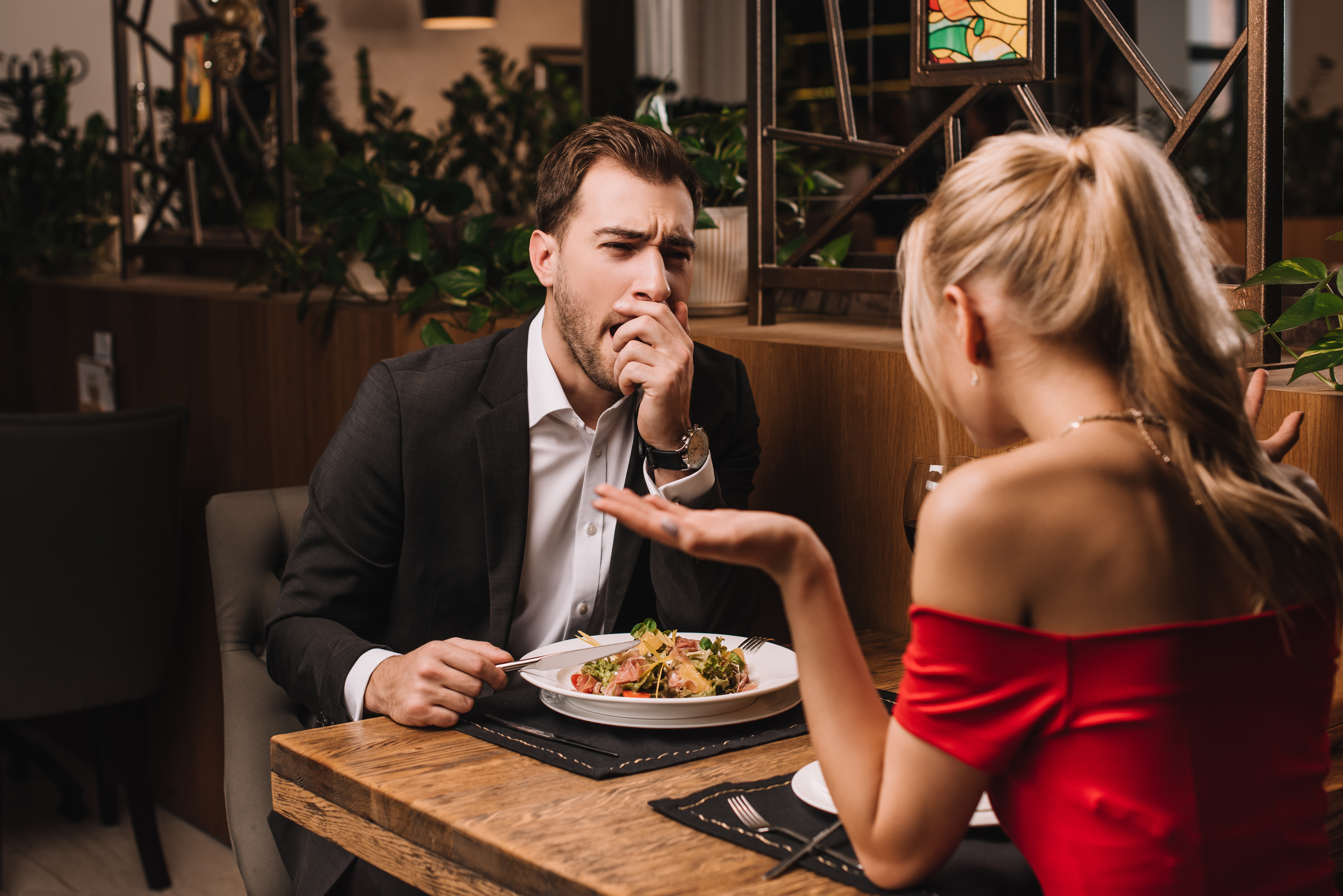 man yawning while out on a dinner date