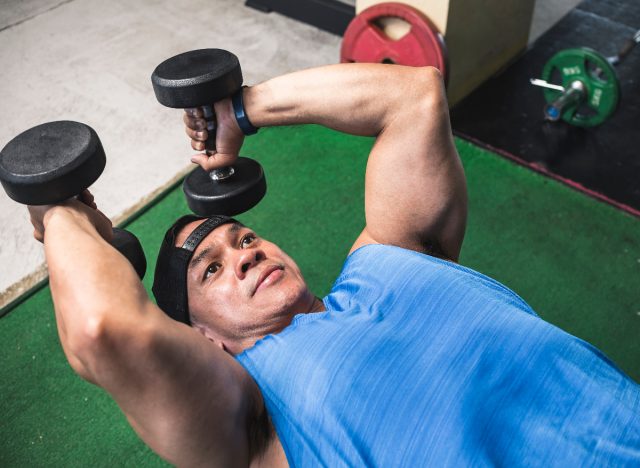 man performing skull crusher exercise in arm workout