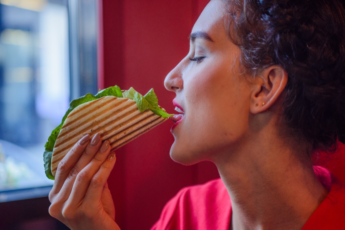 Young,Woman,Dressed,In,Red,Dress,Eating,Tacos,Mexicanos,Into