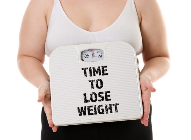 woman holding scale signs you need to lose weight concept