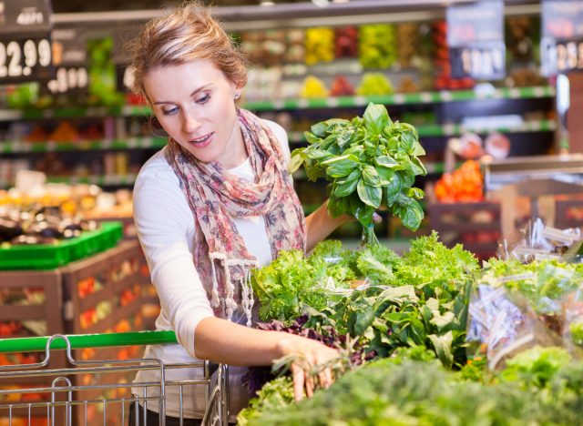 woman choosing green veggies while at the grocery store