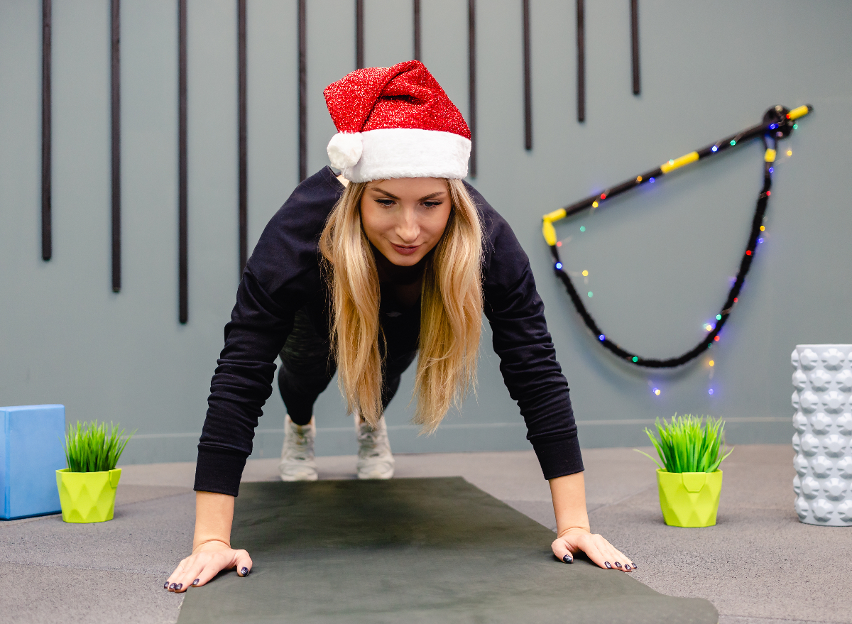 woman dressed in santa hat doing Christmas workout, easy fitness habits over the holidays