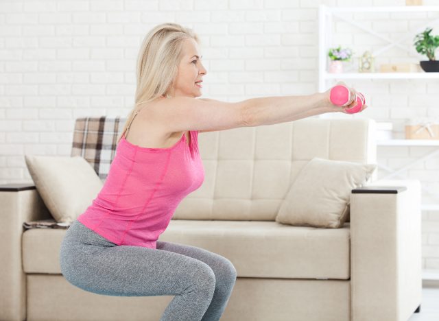 woman doing dumbbell squats at home