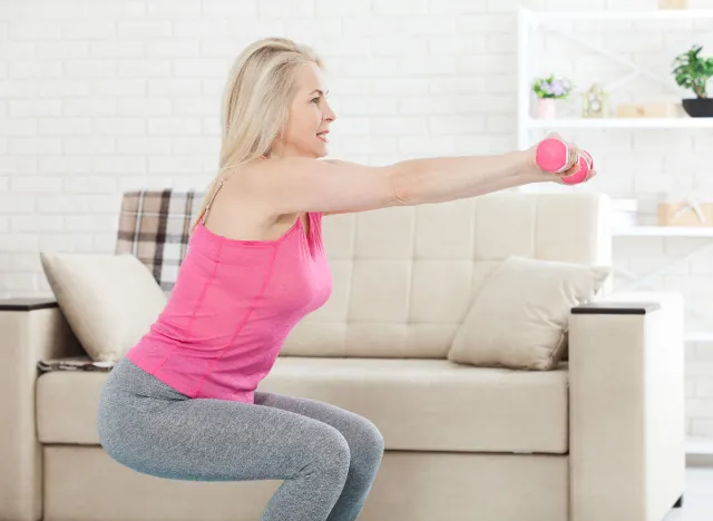 woman doing dumbbell squats at home