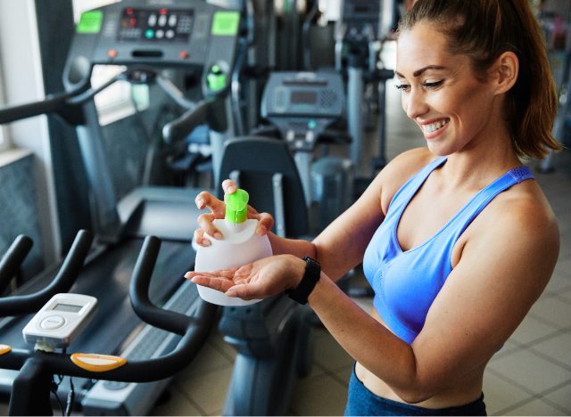 woman applying hand sanitizer at the gym