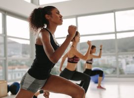 woman performing high-intensity aerobic exercise in group fitness class