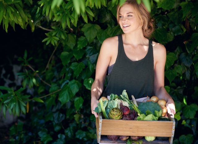 woman holding crate of veggies