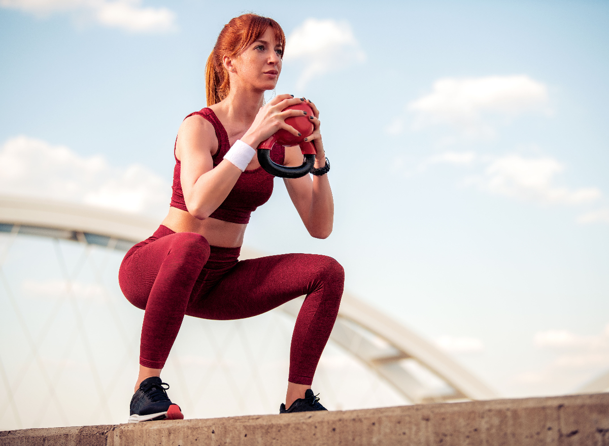 fitness woman doing kettlebell squats outdoors, workout for rapid weight loss