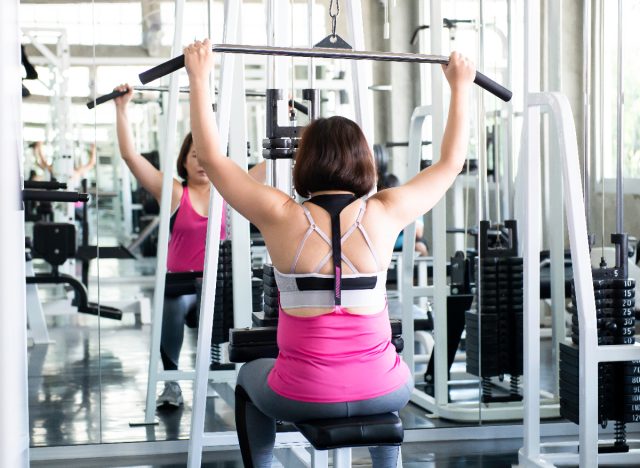 woman demonstrating lat pulldown exercises to lift your breasts