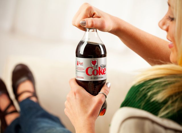 woman opening diet coke bottle