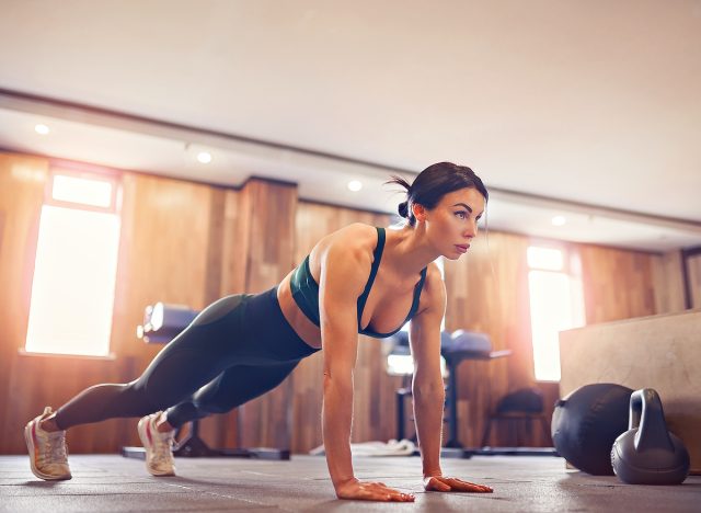 woman doing pushups in her home basement