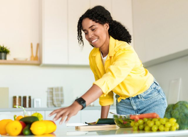 woman reaching for fruit in kitchen, example of primal movement patterns