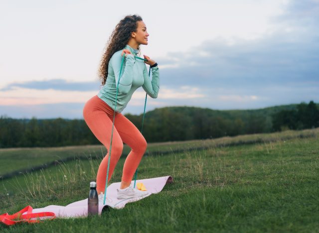 woman demonstrating resistance band squat exercises to get stronger as you age