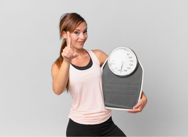 woman holding scale, weight loss concept