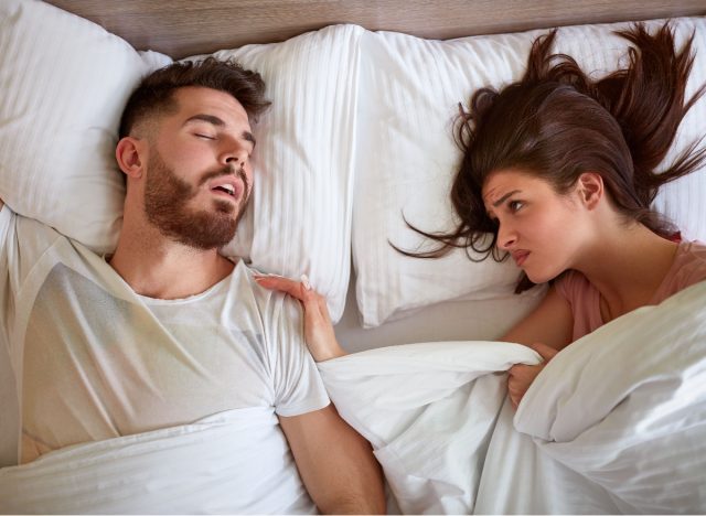 woman sharing a bed with her restless partner