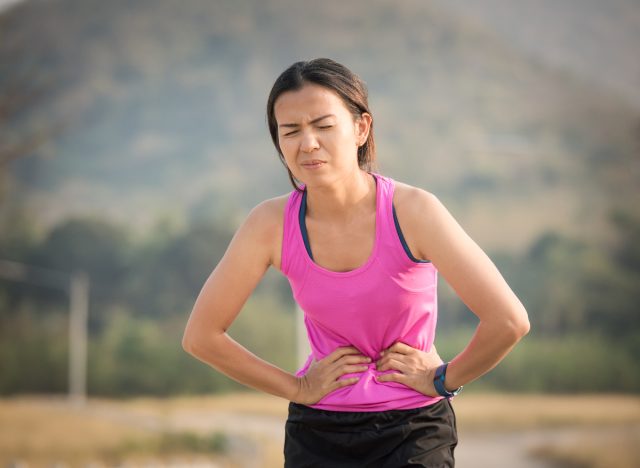 woman experiencing an upset stomach during her workout, side effect of exercise after eating