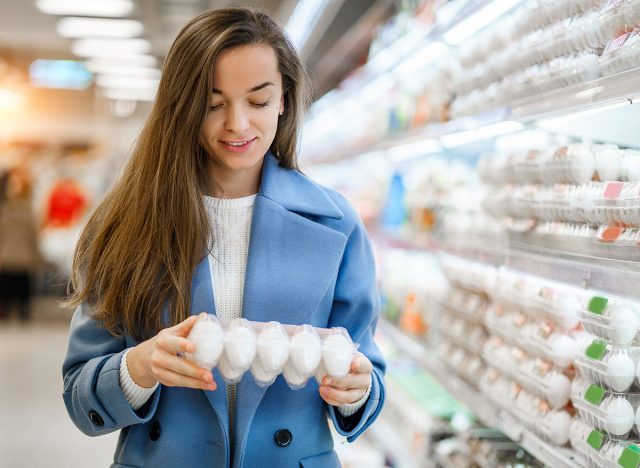 Young woman shopper buying fresh eggs