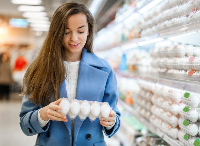 Young woman shopper buying fresh eggs