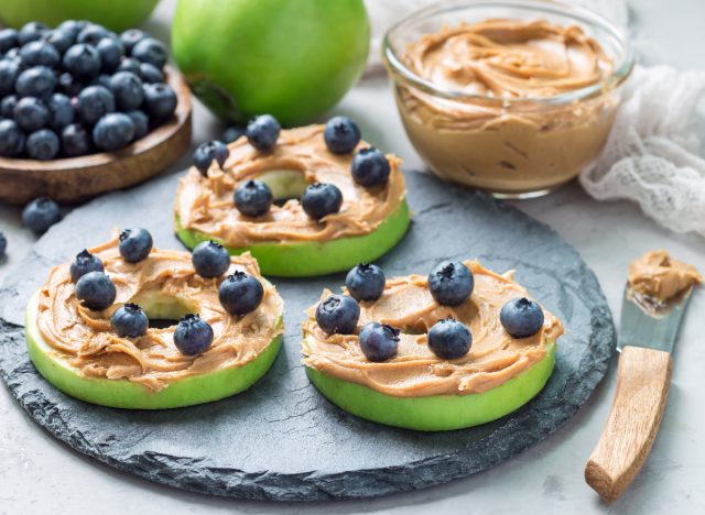 blueberries with nut butter apple slice sandwiches, concept of healthy foods trainers eat every day to stay fit