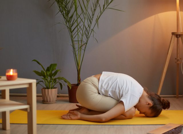 woman doing child's pose as part of wind-down routine for weight loss before bed