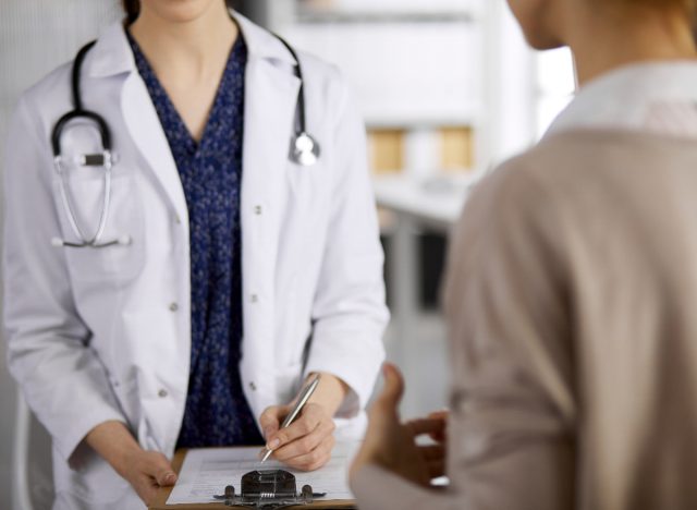 close-up woman chatting with female doctor in exam room