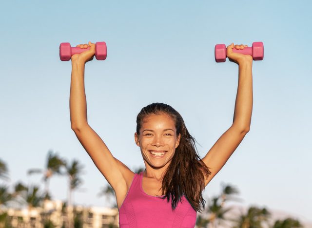 woman doing dumbbell arnold press outdoors